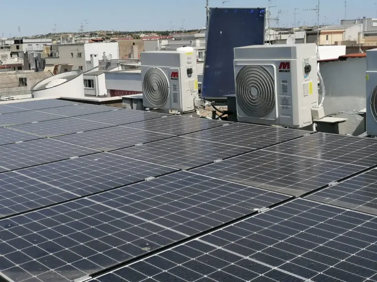 Pannelli fotovoltaici e unità esterne di pompe di calore su un tetto piano Pannelli fotovoltaici e unità esterne di pompe di calore su un tetto piano
